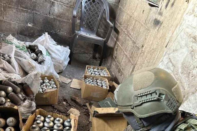 Soldado de Israel mostra o que seriam explosivos apreendidos durante a incursão 