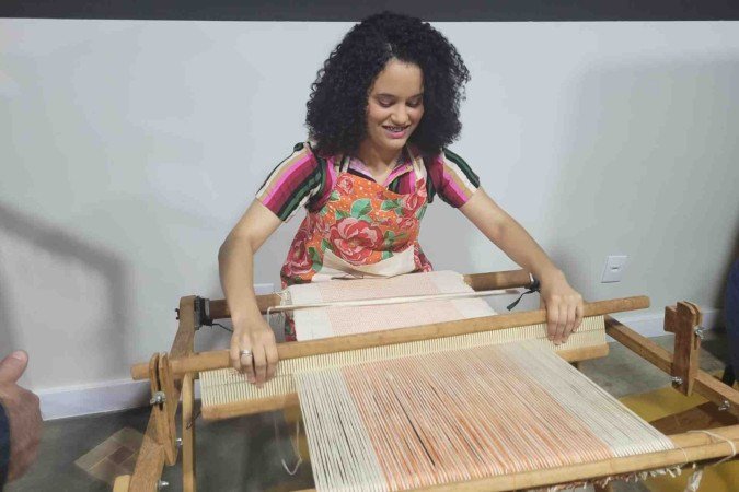 Amanda Custódio demonstrando a forma correta de usar a máquina de tecer