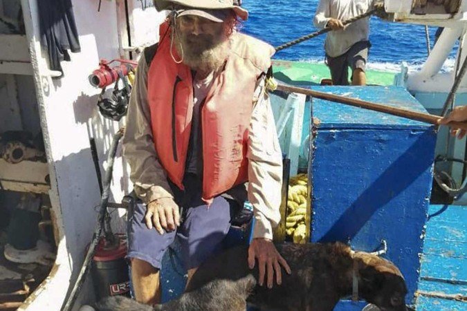 Marinheiro australiano Tim Shaddock e seu cachorro Bella após serem resgatados pela tripulação de um atuneiro mexicano, parte da frota do Grupomar, no Oceano Pacífico em 17 de julho de 2023.  -  (crédito: Reprodução/ Handout / Grupomar / AFP)