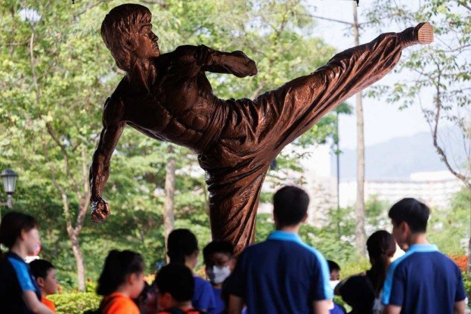 Visitantes tiram fotos com uma estátua de Bruce Lee do lado de fora do Hong Kong Heritage Museum, em Hong Kong - (crédito: May James/AFP) Visitantes tiram fotos com uma estátua de Bruce Lee do lado de fora do Hong Kong Heritage Museum, em Hong Kong - (crédito: May James/AFP)
