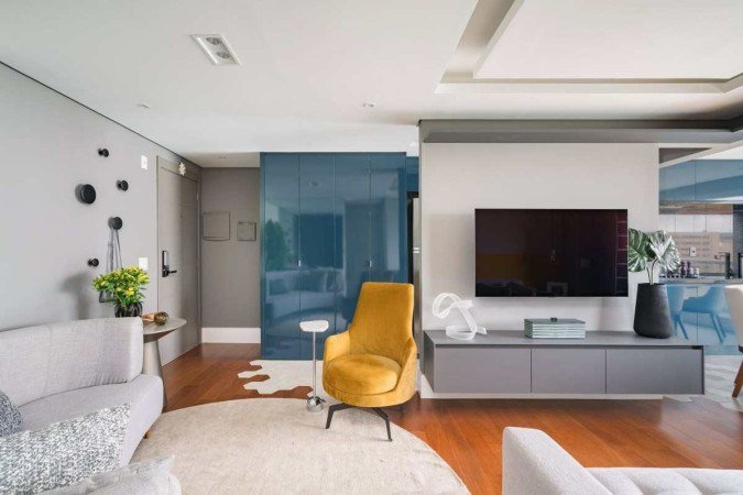 Área de serviços oculta por marcenaria azul, criada pelo escritório Spaço Interior