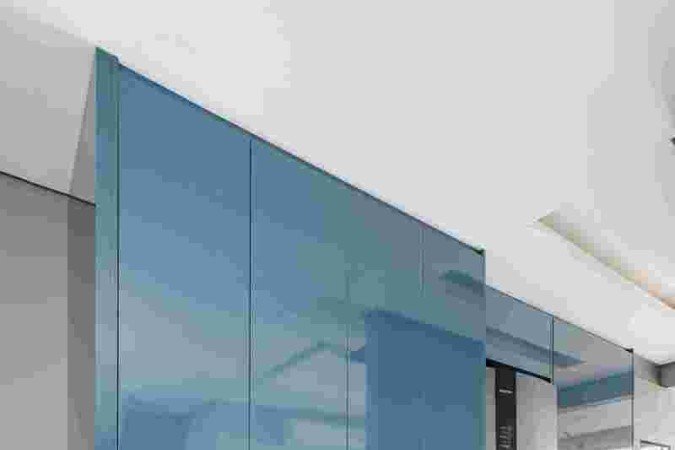 Área de serviços oculta por marcenaria azul, criada pelo escritório Spaço Interior