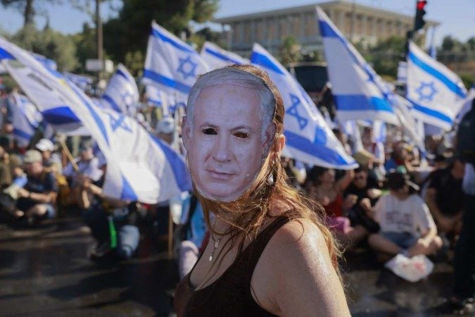 Manifestante usa máscara com rosto de Netanyahu, durante ato na entrada do prédio do Knesset, em Jerusalém, na segunda-feira passada: tensão nas ruas - (crédito: Menahem Kahana/AFP) Manifestante usa máscara com rosto de Netanyahu, durante ato na entrada do prédio do Knesset, em Jerusalém, na segunda-feira passada: tensão nas ruas - (crédito: Menahem Kahana/AFP)