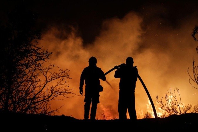 Turistas abrigados em um estádio em decorrência de incêndios florestais - (crédito: Reprodução/ EPA-EFE/REX/Shutterstock) Turistas abrigados em um estádio em decorrência de incêndios florestais - (crédito: Reprodução/ EPA-EFE/REX/Shutterstock)