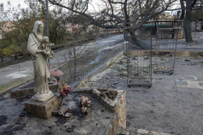 Estátua da Virgem Maria no posto de gasolina incendiado na cidade de Oliveri       -  (crédito: GIOVANNI ISOLINO / AFP)