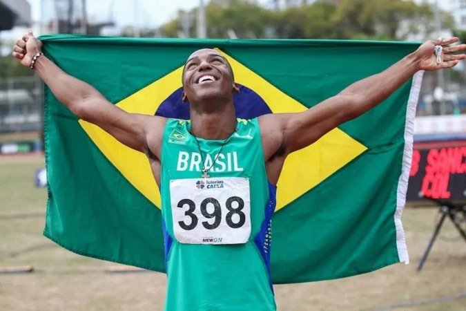 Erik Cardoso posa com a bandeira do Brasil após a prata nos 100m -  (crédito: Wagner Carmo/CBAt)