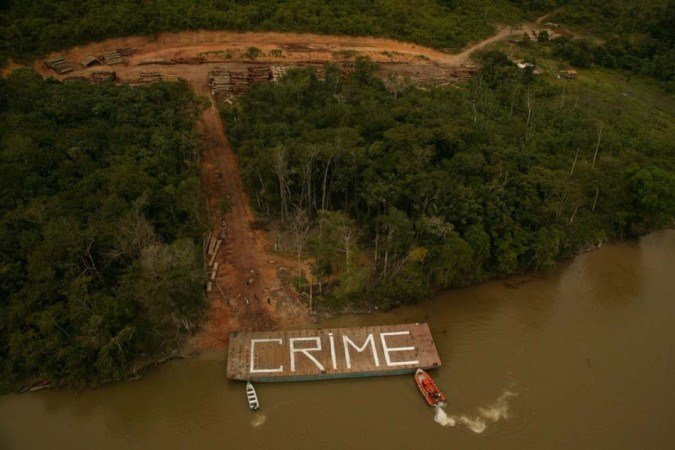 O Greenpeace descobriu uma operação madeireira ilegal com pelo menos 200 km de estradas servindo aos madeireiros. Ativistas do Greenpeace pintaram a barcaça dos madeireiros com a mensagem 'CRIME' e a usaram para bloquear o acesso ao pátio de triagem -  (crédito: Greenpeace/Daniel Beltrá)
