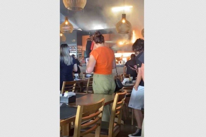 Em imagens que circulam nas redes sociais, é possível observar clientes deixando o espaço após o fogo se espalhar - (crédito: Reprodução/Redes sociais) Em imagens que circulam nas redes sociais, é possível observar clientes deixando o espaço após o fogo se espalhar - (crédito: Reprodução/Redes sociais)