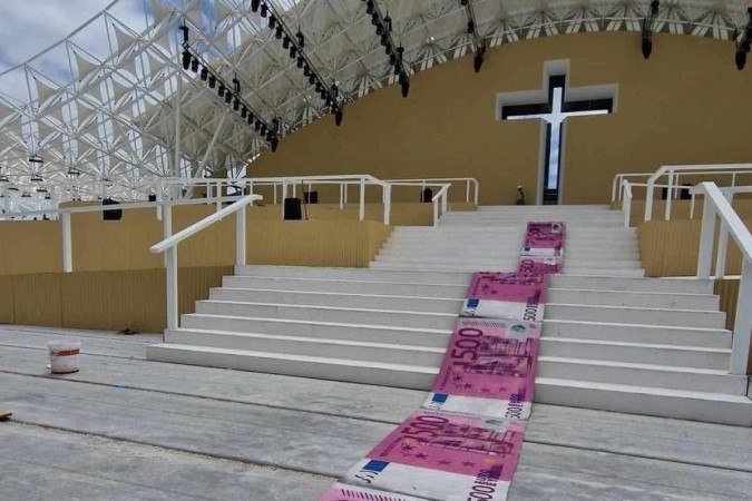 o artista espalhou em um tapete representações gigantes de notas de 500 euros no altar onde o papa Francisco celebrará uma missa
- (crédito: Reprodução/Instagram @b0rdalo_ii) o artista espalhou em um tapete representações gigantes de notas de 500 euros no altar onde o papa Francisco celebrará uma missa
- (crédito: Reprodução/Instagram @b0rdalo_ii)