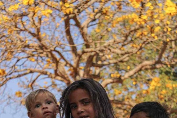   04/08/2023 Crédito: Kayo Magalhães/CB/D.A Press. Brasil. Brasilia - DF. Cidades. Ipê amarelo colore Brasília. Na foto, Yasmin (1), John Alice (7), John (4).