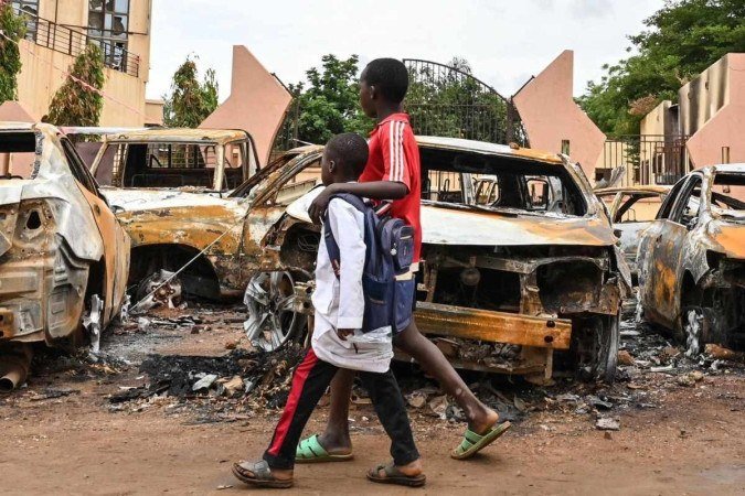Carcaças de carros diante da sede do partido do líder deposto, em Niamey   -  (crédito: AFP)