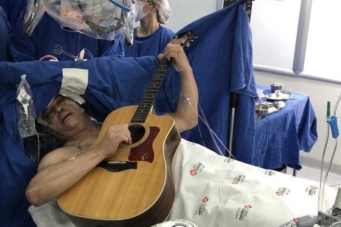 O paciente Maurício Stemberg durante cirurgia para retirada de tumor cerebral, tocando violão e cantando - (crédito: Hospital Universitário Cajuru) O paciente Maurício Stemberg durante cirurgia para retirada de tumor cerebral, tocando violão e cantando - (crédito: Hospital Universitário Cajuru)