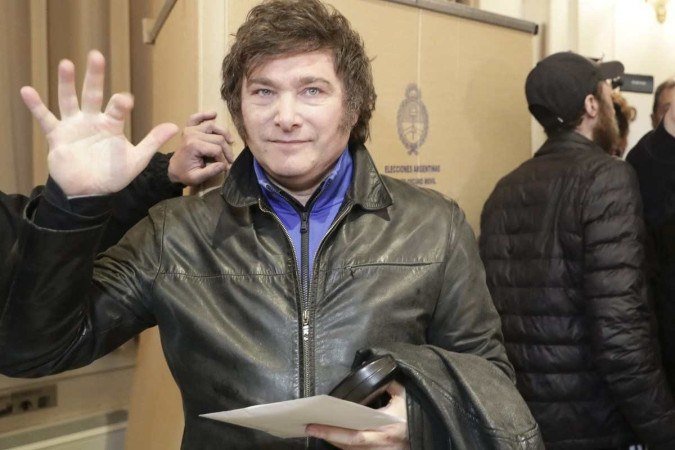 Milei acena para jornalistas antes de votar, em 13/8, em Buenos Aires 