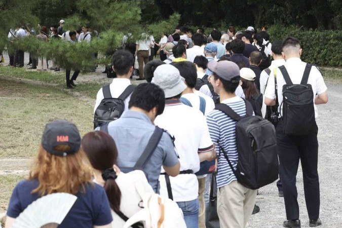 Pessoas esperam na fila por ingressos para assistir ao primeiro julgamento de Shinji Aoba, réu no caso de incêndio criminoso da Kyoto Animation -  (crédito: STR / JIJI PRESS / AFP)