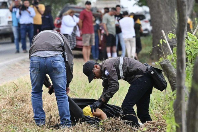 Policiais cobrem o corpo de Bolívar Vera, em bosque da província de Guayas: mais um episódio de violência política - (crédito: AFP) Policiais cobrem o corpo de Bolívar Vera, em bosque da província de Guayas: mais um episódio de violência política - (crédito: AFP)