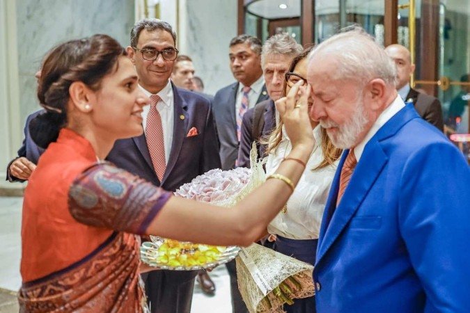 Na chegada a Nova Délhi, o presidente Lula recebeu flores e teve a testa marcada pelo Na chegada a Nova Délhi, o presidente Lula recebeu flores e teve a testa marcada pelo
