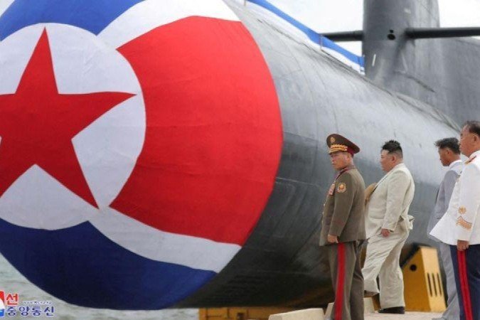 Kim Jong-un inspecionou o exterior do submarino com seus chefes militares. - (crédito: Reuters) Kim Jong-un inspecionou o exterior do submarino com seus chefes militares. - (crédito: Reuters)