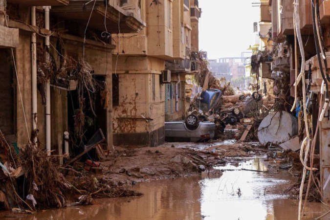 Carros virados em meio aos escombros, em uma das ruas destruídas de Derna: cenário de devastação impressionante - (crédito: AFP) Carros virados em meio aos escombros, em uma das ruas destruídas de Derna: cenário de devastação impressionante - (crédito: AFP)