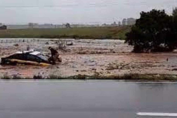 Nas imagens gravadas por um motorista que estava no local, é possível ver um oficial da PRF em cima do capô do veículo, enquanto ele é arrastado pela correnteza. - (crédito: Reprodução) Nas imagens gravadas por um motorista que estava no local, é possível ver um oficial da PRF em cima do capô do veículo, enquanto ele é arrastado pela correnteza. - (crédito: Reprodução)