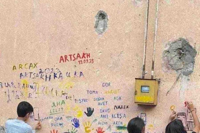 Crianças de Stepanakert deixam seus nomes inscritos na parede de uma casa 