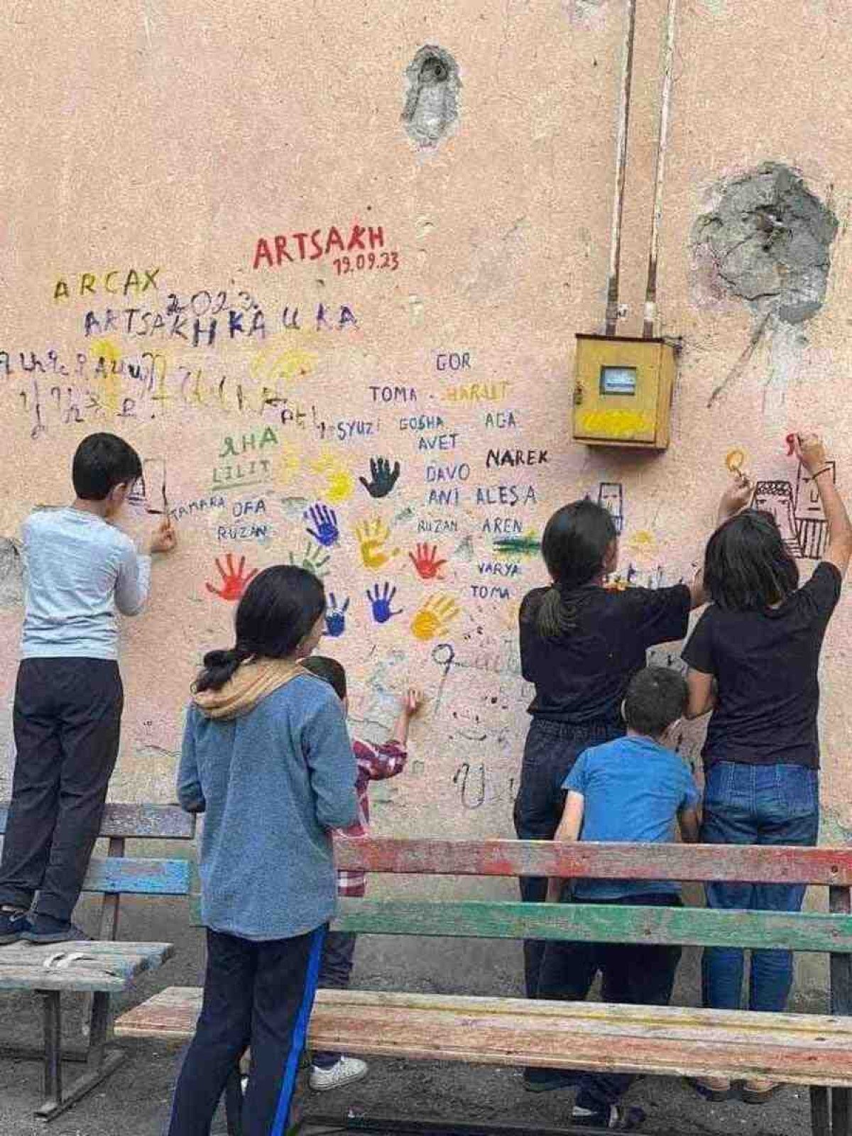 Crianças de Stepanakert deixam seus nomes inscritos na parede de uma casa 