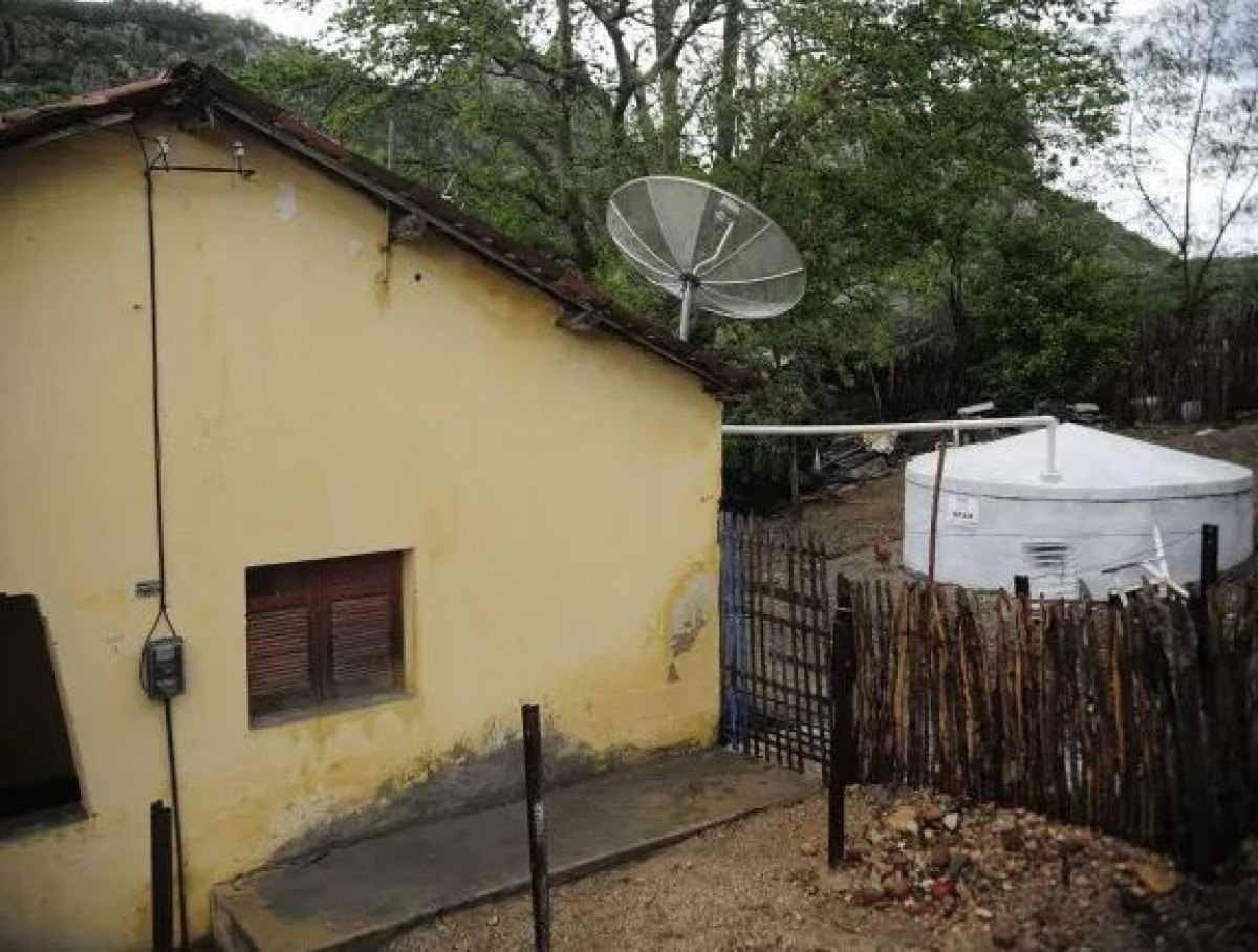 Cisterna construída ao lado de residência rural para captação de água da chuva em Quixadá (CE) 