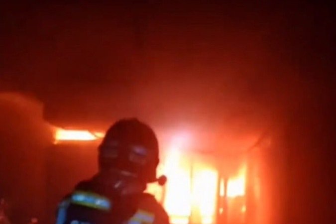 Brigadista avança pelo interior do mesmo prédio: labaredas ganharam força com rapidez