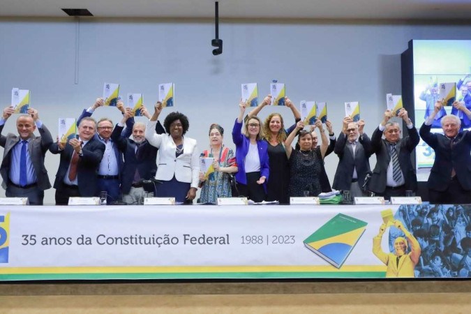 Os parlamentares que participaram do seminário repetiram o gesto de Ulysses Guimarães e, juntos, levantaram um exemplar da Constituição -  (crédito: Mario Agra / Câmara dos Deputados)