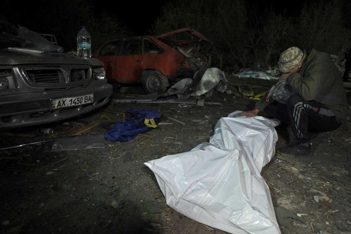 Sergiy, morador da aldeia de Groza, diante do corpo da esposa, Svitlana, morta no ataque aéreo 