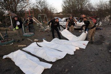 Policiais carregam corpos retirados de mercearia, depois do ataque aéreo em Groza, a 30km de Kupiansk -  (crédito: Anatolii Stepanov/AFP)