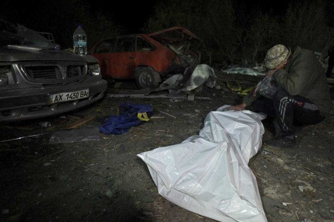 Sergiy, morador da aldeia de Groza, diante do corpo da esposa, Svitlana, morta no ataque aéreo 