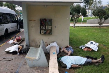 Corpos de civis cobertos em ponto de ônibus, na cidade de Sderot: execuções sumárias em ruas de várias localidades do sul do país -  (crédito: Oren Ziv/AFP)