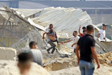 Um homem carrega um palestino atingido em um ataque aéreo israelense na passagem de Erez entre Israel e o norte da Faixa de Gaza -  (crédito: BASHAR TALEB/AFP)