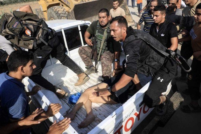 Militantes diante de mulher capturada após o ataque de 7 de outubro e levada para a Faixa de Gaza em picape