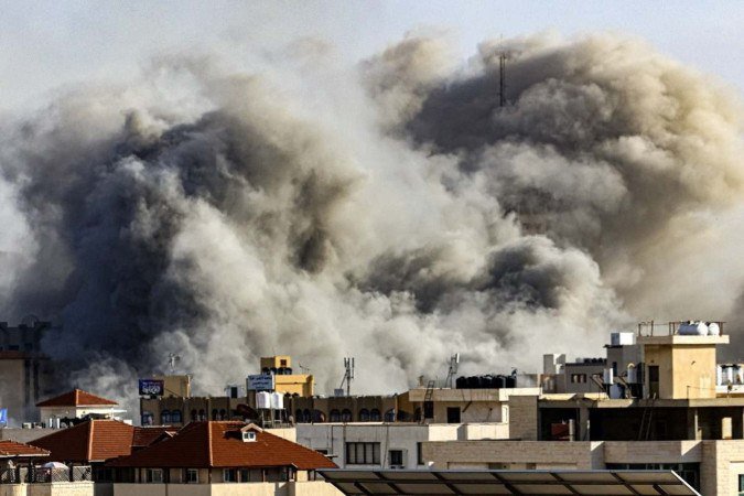 Plumas de fumaça sobem sobre a cidade de Gaza em 7 de outubro de 2023 durante ataques aéreos israelenses, após a invasão surpresa do Hamas em Israel, com uso de mais de 5 mil foguetes. Militantes palestinos iniciaram uma "guerra" contra Israel, disse o ministro da defesa - (crédito: MAHMUD HAMS / AFP) Plumas de fumaça sobem sobre a cidade de Gaza em 7 de outubro de 2023 durante ataques aéreos israelenses, após a invasão surpresa do Hamas em Israel, com uso de mais de 5 mil foguetes. Militantes palestinos iniciaram uma "guerra" contra Israel, disse o ministro da defesa - (crédito: MAHMUD HAMS / AFP)