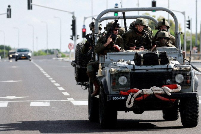 Militares israelenses avançam em uma estrada no sul de Israel, enquanto foguetes são lançados da Faixa de Gaza, nos arredores da cidade de Sderot - (crédito: Reuters) Militares israelenses avançam em uma estrada no sul de Israel, enquanto foguetes são lançados da Faixa de Gaza, nos arredores da cidade de Sderot - (crédito: Reuters)