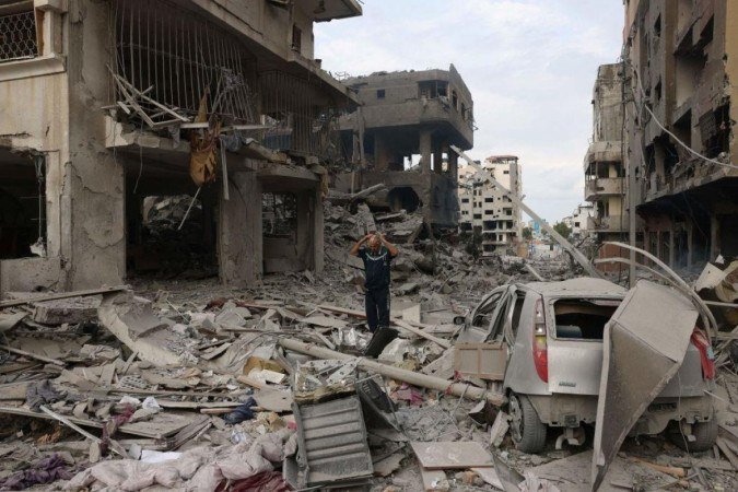 Homem palestino caminha entre escombros em meio à destruição causada por ataques aéreos israelenses no bairro de al-Rimal, na cidade de Gaza, no início de 10 de outubro de 2023 - (crédito: Getty Images) Homem palestino caminha entre escombros em meio à destruição causada por ataques aéreos israelenses no bairro de al-Rimal, na cidade de Gaza, no início de 10 de outubro de 2023 - (crédito: Getty Images)