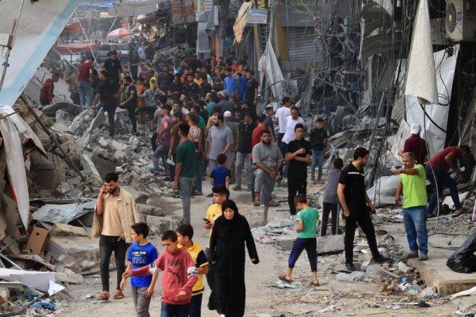 Palestinos caminham entre os escombros de edifícios destruídos - (crédito: AFP) Palestinos caminham entre os escombros de edifícios destruídos - (crédito: AFP)
