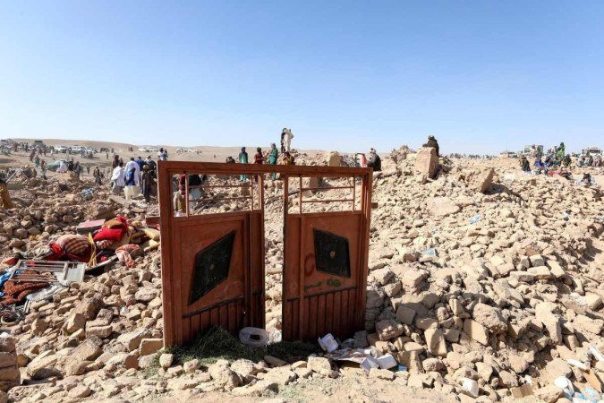 Residentes afegãos limpam os escombros enquanto procuram os corpos das vítimas nos escombros de casas danificadas após os terremotos - (crédito: Mohsen KARIMI / AFP) Residentes afegãos limpam os escombros enquanto procuram os corpos das vítimas nos escombros de casas danificadas após os terremotos - (crédito: Mohsen KARIMI / AFP)