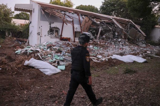 Uma equipe de resgate a por corpos cobertos no kibutz Beeri, perto da fronteira com Gaza, local de uma infiltração de militantes palestinos no fim de semana, em 11 de outubro de 2023. - (crédito: MENAHEM KAHANA / AFP) Uma equipe de resgate a por corpos cobertos no kibutz Beeri, perto da fronteira com Gaza, local de uma infiltração de militantes palestinos no fim de semana, em 11 de outubro de 2023. - (crédito: MENAHEM KAHANA / AFP)