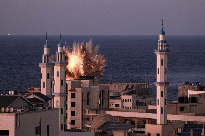Uma bola de fogo irrompe de um ataque aéreo israelense na cidade de Gaza nesta quinta-feira (12/10). Mais de 1,4 mil morreram na cidade que é alvo de Israel após a invasão e o ataque violento do Hamas, no sábado (7/10), que matou 1,3 mil israelenses
- (crédito: MAHMUD HAMS/AFP) Uma bola de fogo irrompe de um ataque aéreo israelense na cidade de Gaza nesta quinta-feira (12/10). Mais de 1,4 mil morreram na cidade que é alvo de Israel após a invasão e o ataque violento do Hamas, no sábado (7/10), que matou 1,3 mil israelenses
- (crédito: MAHMUD HAMS/AFP)