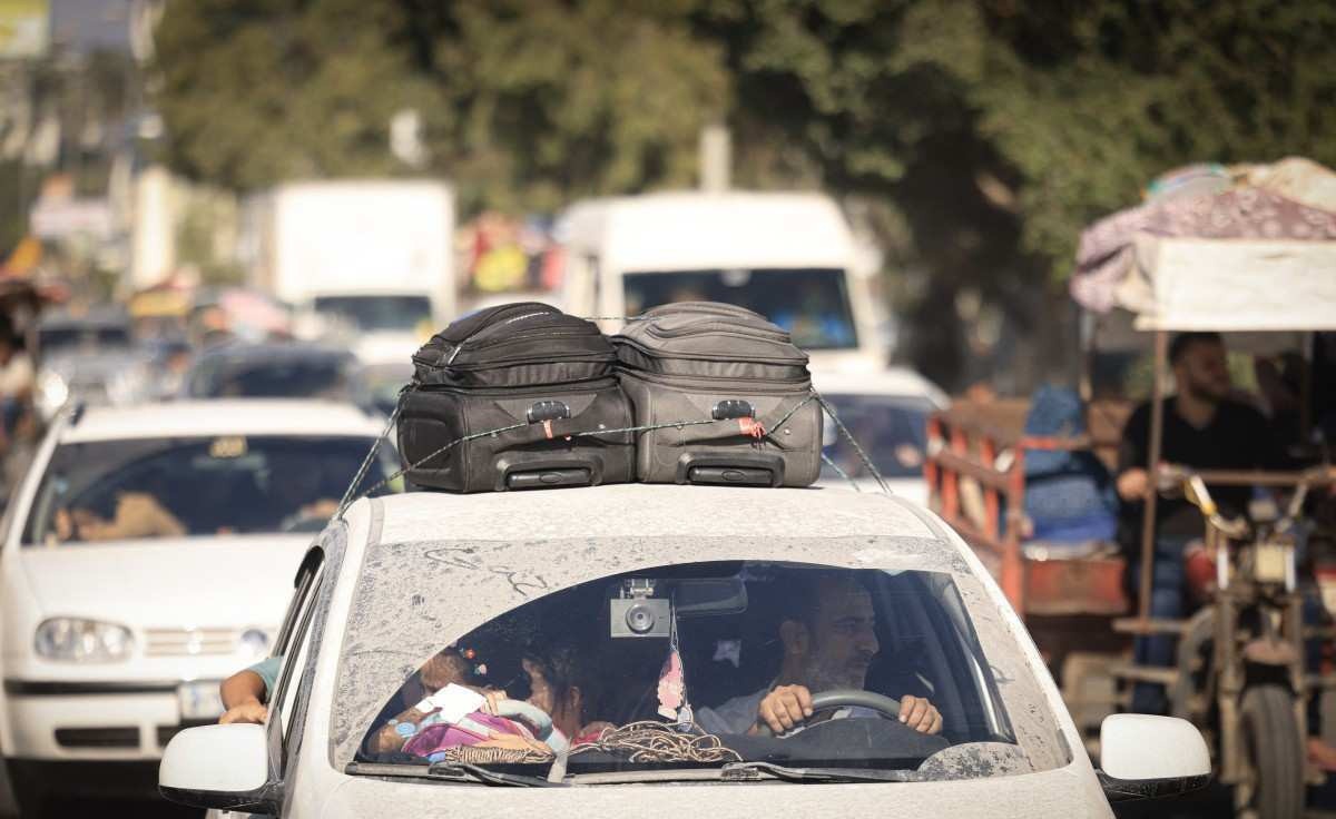 Palestinos com seus pertences lotam uma rua na Cidade de Gaza enquanto fogem de suas casas após o alerta do exército israelense em 13 de outubro de 2023.       