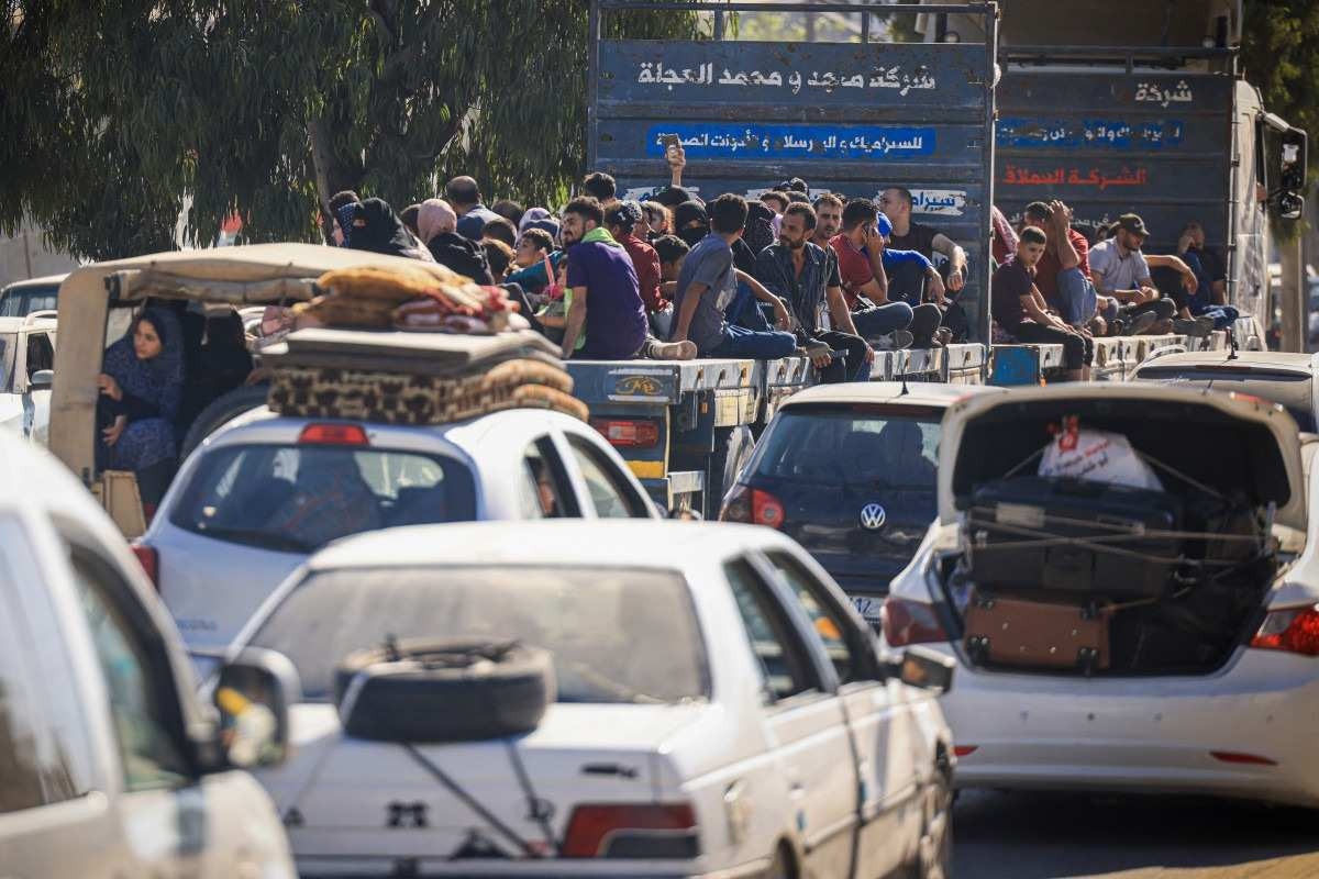 Palestinos com seus pertences lotam uma rua na Cidade de Gaza enquanto fogem de suas casas após o alerta do exército israelense em 13 de outubro de 2023. 