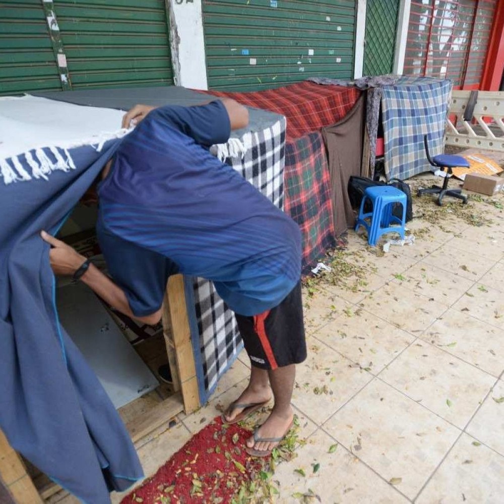 Caminhões e veículos dos Correios utilizam calçada como