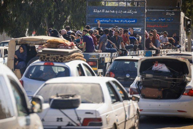 Palestinos com seus pertences lotam uma rua na Cidade de Gaza enquanto fogem de suas casas após o alerta do exército israelense em 13 de outubro de 2023. - (crédito: MAHMUD HAMS / AFP) Palestinos com seus pertences lotam uma rua na Cidade de Gaza enquanto fogem de suas casas após o alerta do exército israelense em 13 de outubro de 2023. - (crédito: MAHMUD HAMS / AFP)