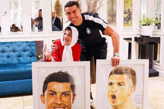Cristiano Ronaldo e a artista iraniana Fatemeh Hamami, que tem 85% do corpo paralisado - (crédito: Reprodução) Cristiano Ronaldo e a artista iraniana Fatemeh Hamami, que tem 85% do corpo paralisado - (crédito: Reprodução)