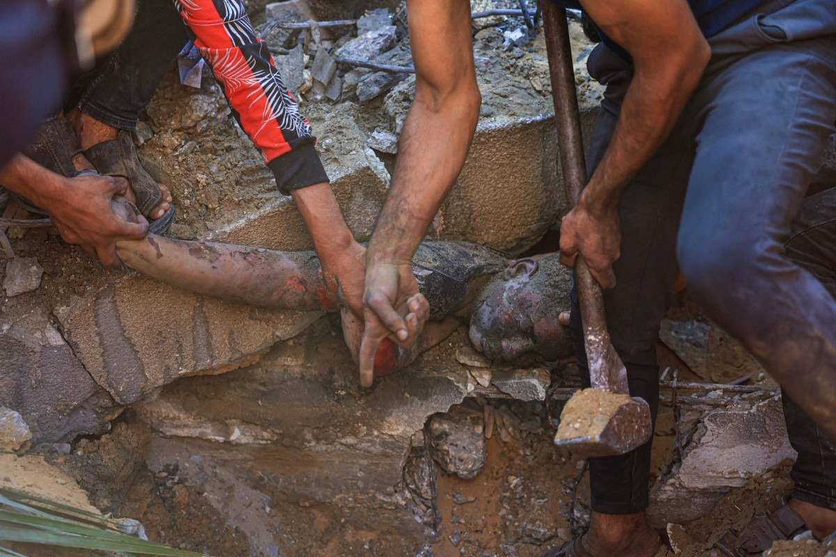 Jovem palestino é resgatado dos escombros de um prédio após bombardeio em Rafah 