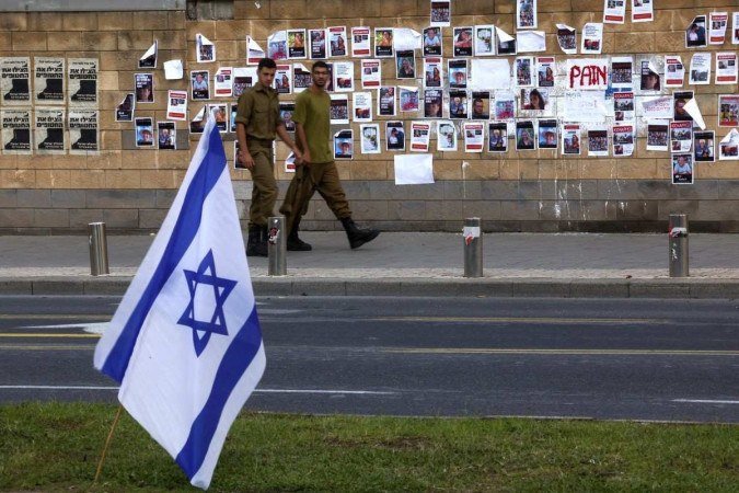 Soldados israelenses passam por imagens de reféns israelenses sequestrados pelo grupo militante palestino Hamas - (crédito: AHMAD GHARABLI / AFP) Soldados israelenses passam por imagens de reféns israelenses sequestrados pelo grupo militante palestino Hamas - (crédito: AHMAD GHARABLI / AFP)