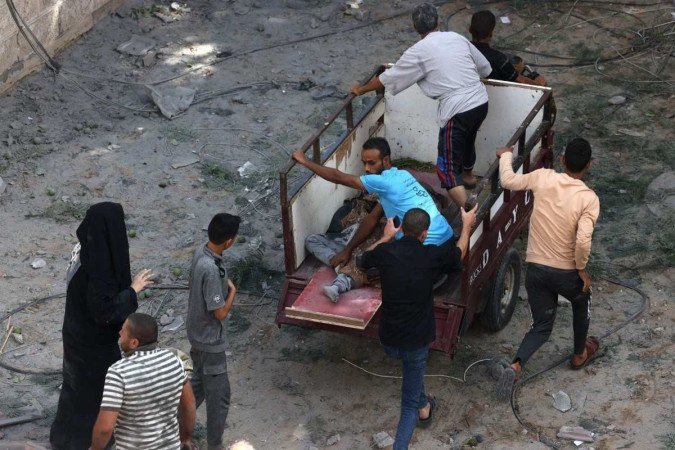 Palestinos retiram uma vítima após um ataque aéreo israelense - (crédito: MOHAMMED ABED / AFP) Palestinos retiram uma vítima após um ataque aéreo israelense - (crédito: MOHAMMED ABED / AFP)