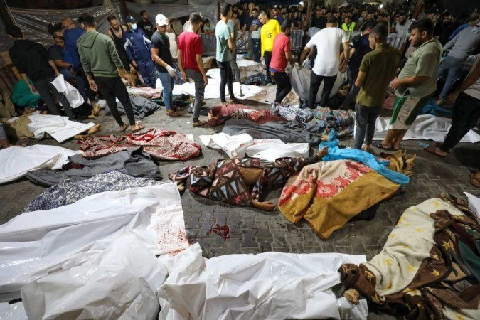 Moradores da Cidade de Gaza observam corpos de palestinos mortos no bombardeio, diante do hospital - (crédito: Dawood Nemer/AFP) Moradores da Cidade de Gaza observam corpos de palestinos mortos no bombardeio, diante do hospital - (crédito: Dawood Nemer/AFP)